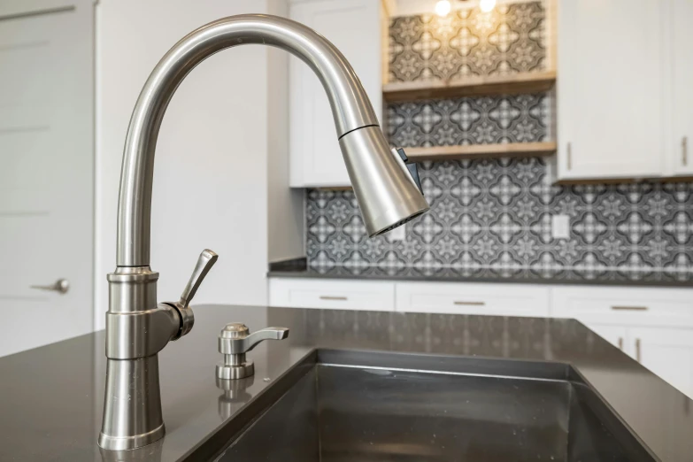 an all stainless steel sink sits in front of a granite countertop