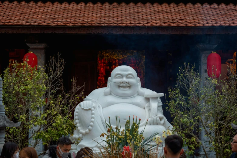 a crowd of people standing around a white statue