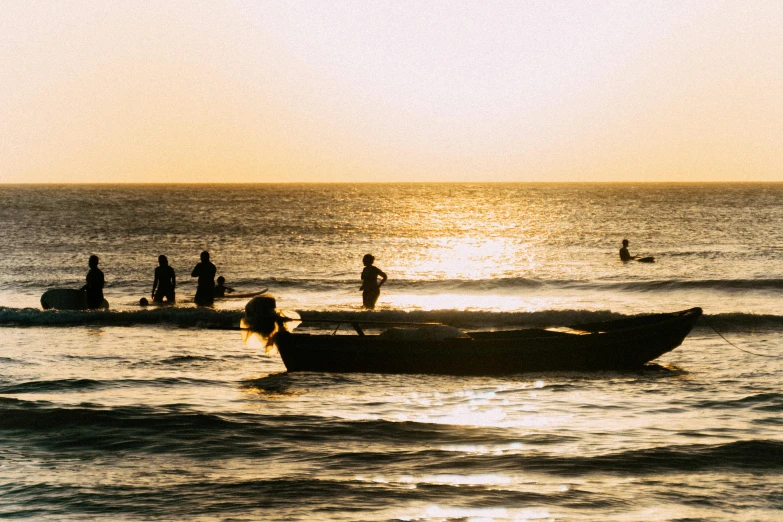 people are swimming in the ocean as a boat is on