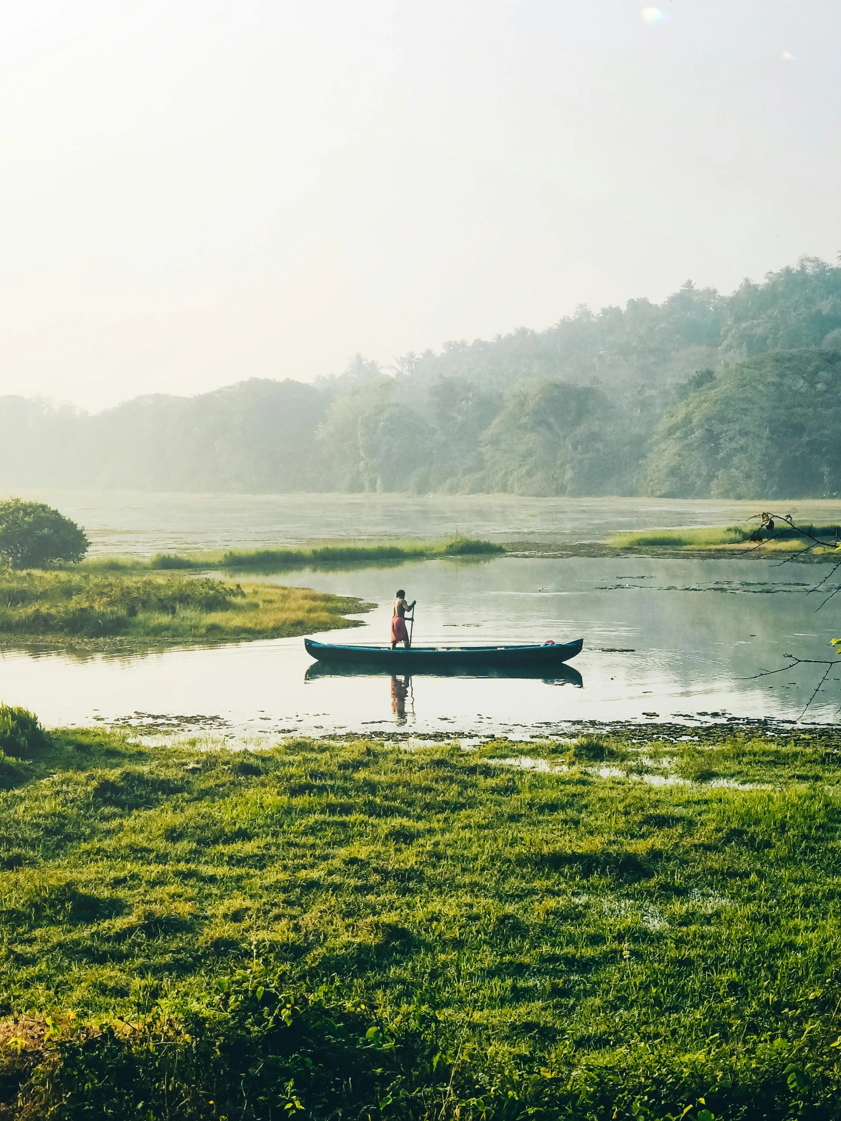 man in small boat out on the river shore