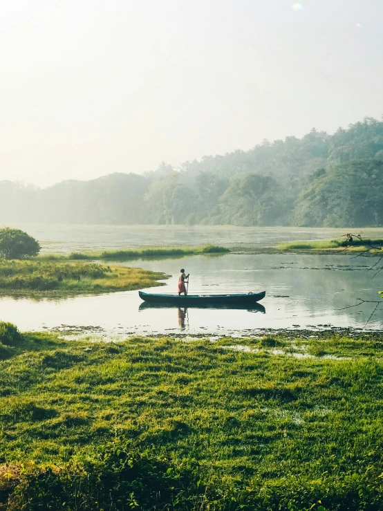 man in small boat out on the river shore