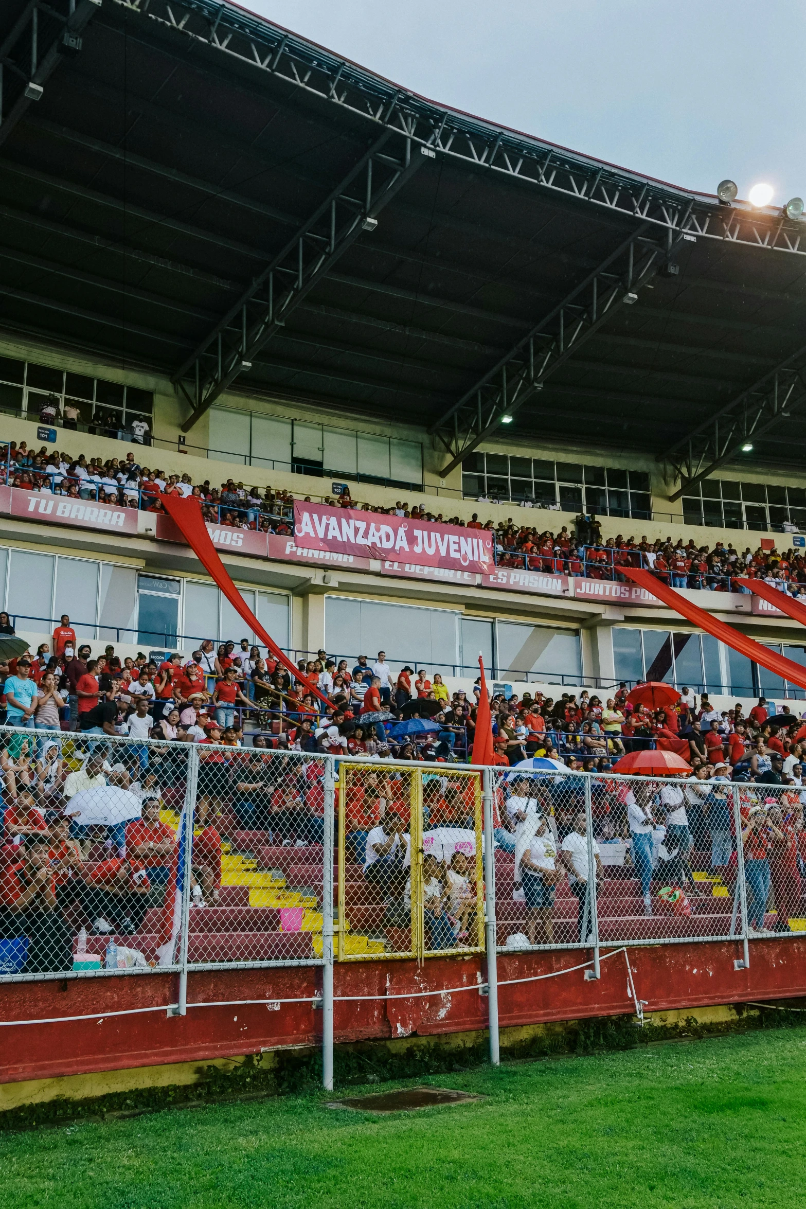 people sitting on seats watching an event at a soccer field