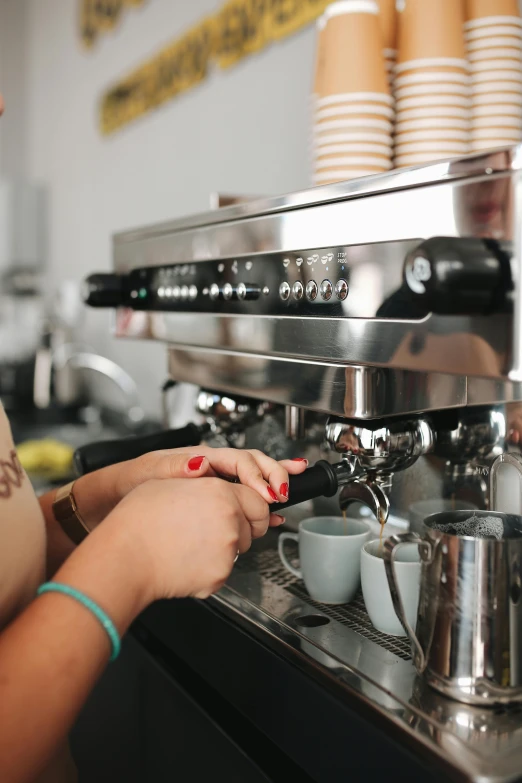 woman filling a cup on a commercial coffee machine