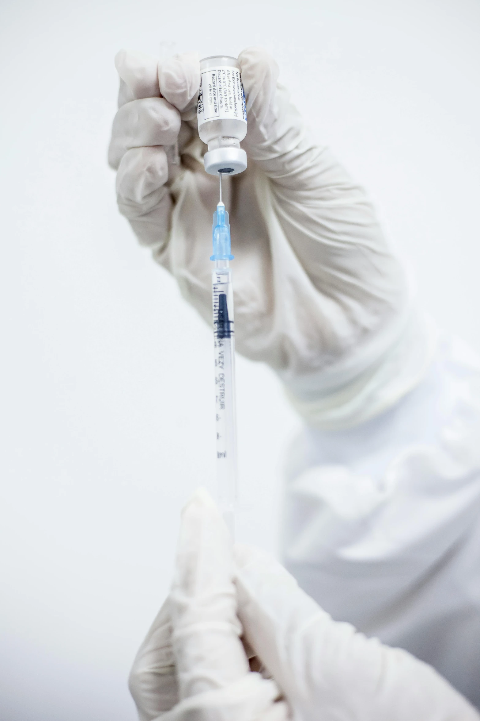 a doctor in white gloves holding a medical tube