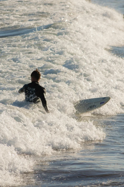 man riding a surfboard on top of a wave in the ocean