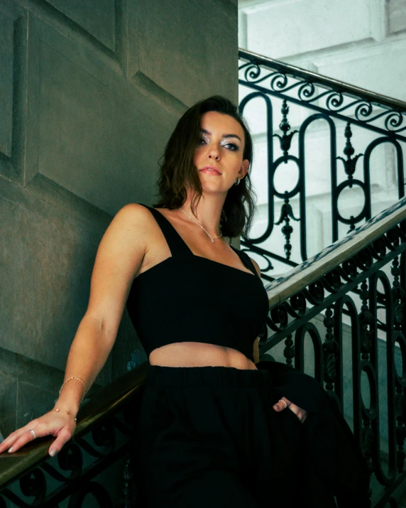 a young woman is sitting on a balcony railing