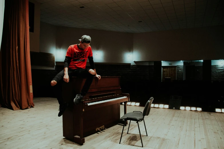 man standing on piano chair near large stage