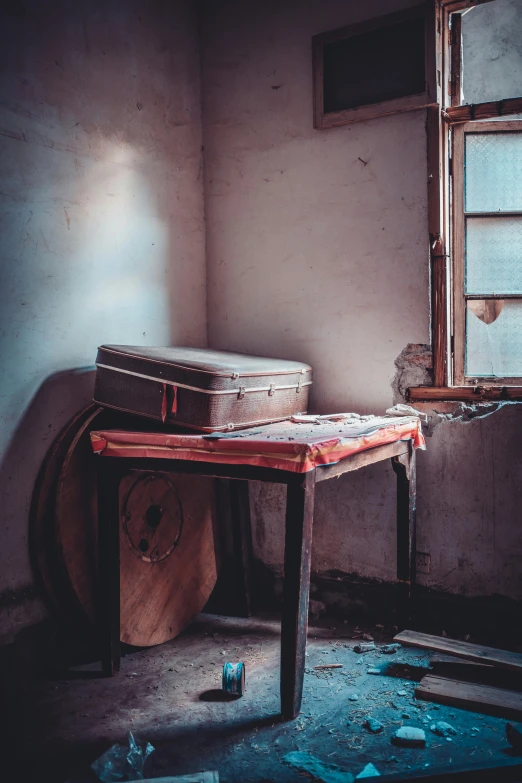 an abandoned room with broken glass and a briefcase sitting on a table