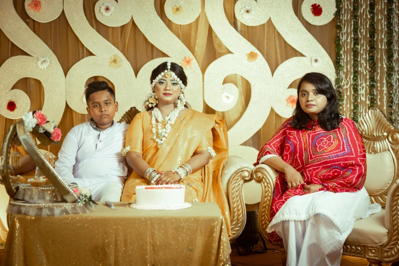 a bride and groom sitting next to their wedding cake