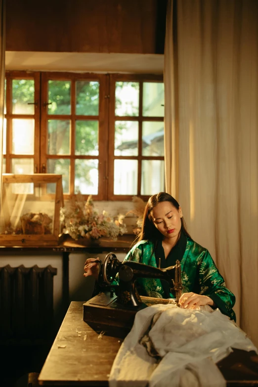 a woman sitting down at a sewing machine