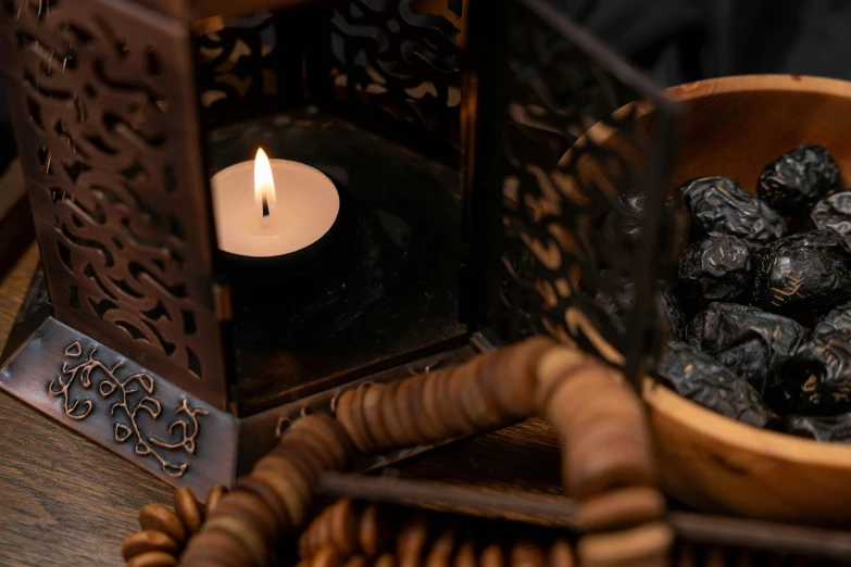 a candle burns on top of some dried berries