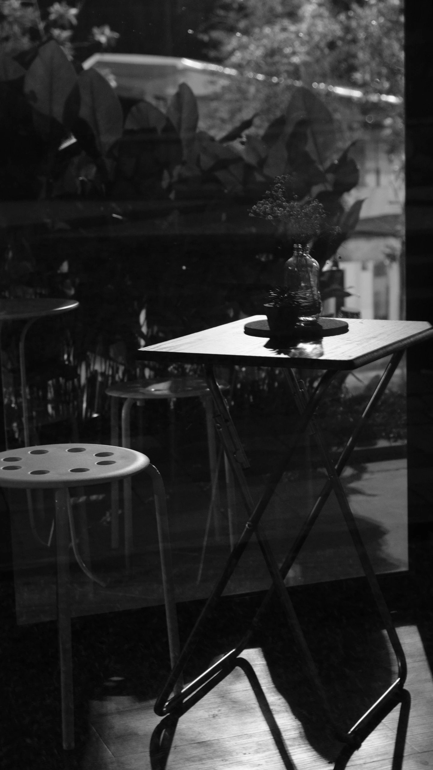 a table with a flower sitting in it next to two chairs