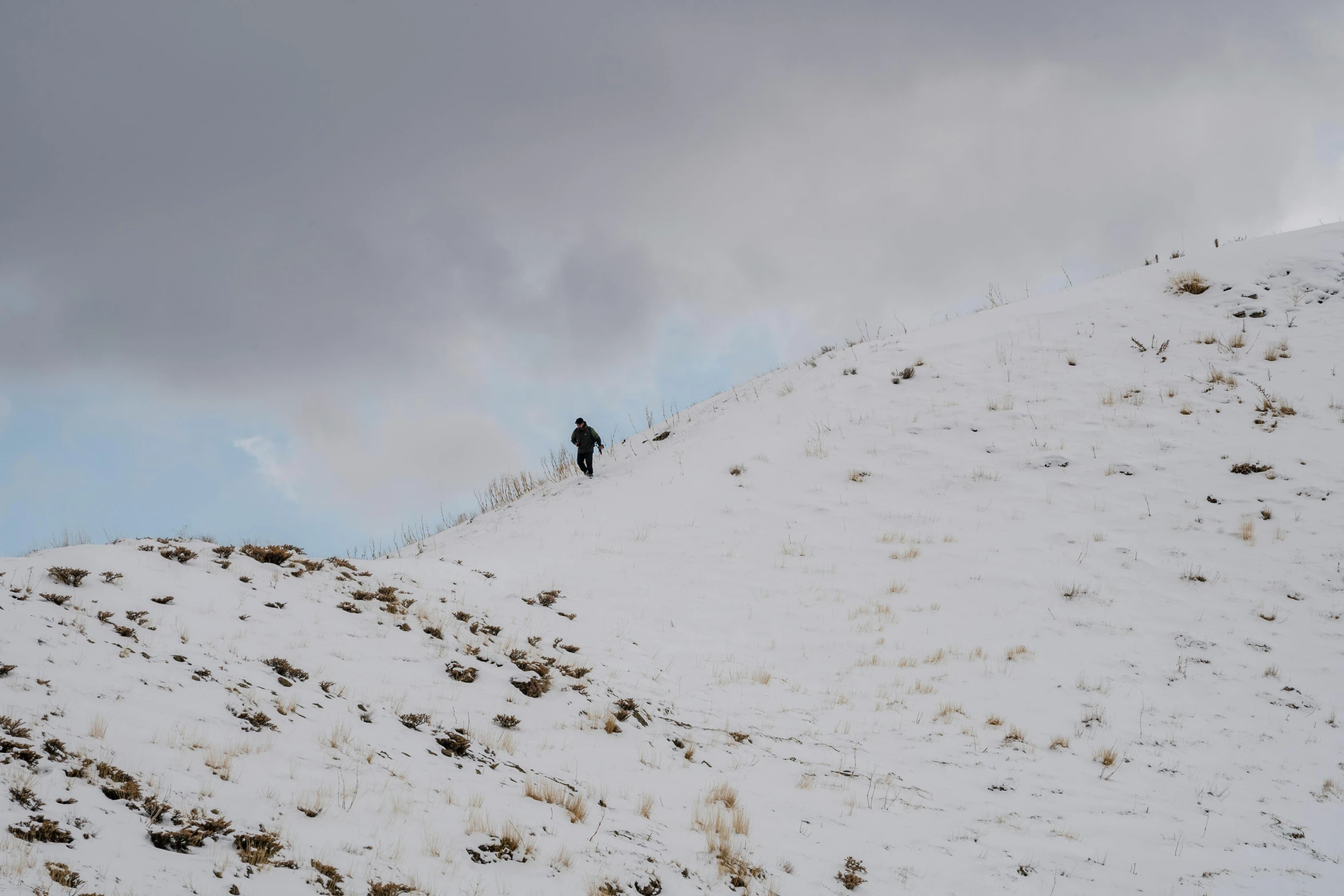 a lone man standing on a snowy slope