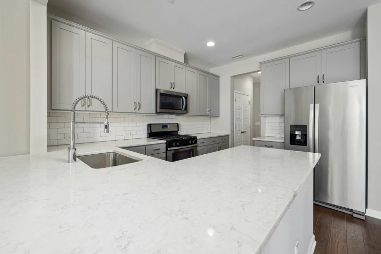 white kitchen with large center island, white appliances and stainless steel appliances