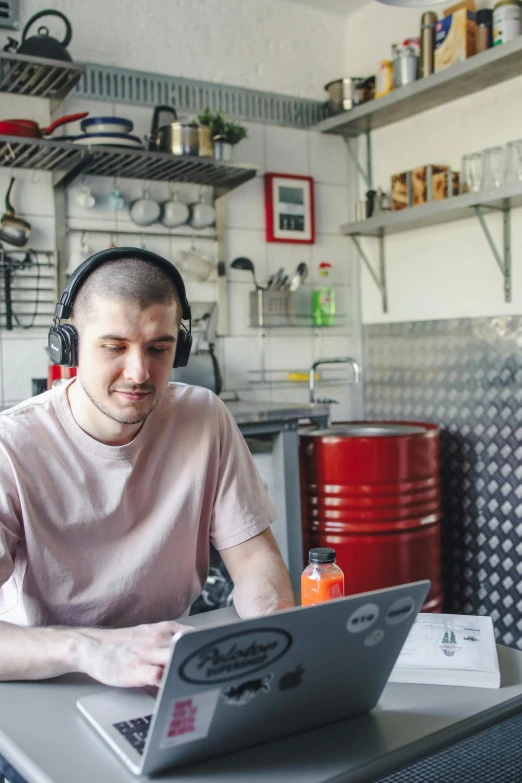 a man wearing headphones while using a laptop