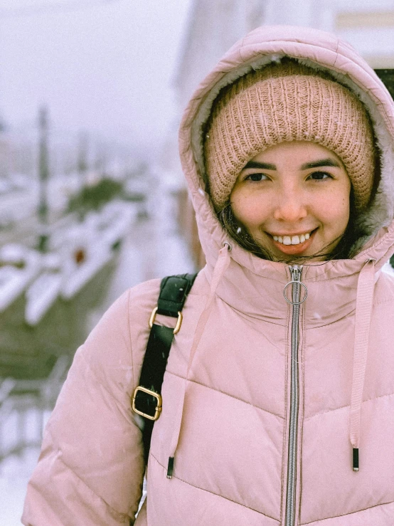 a woman in a pink coat is posing for the camera