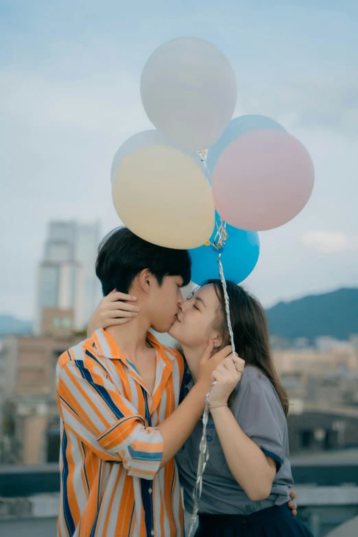 a man holding a woman with balloons on her head