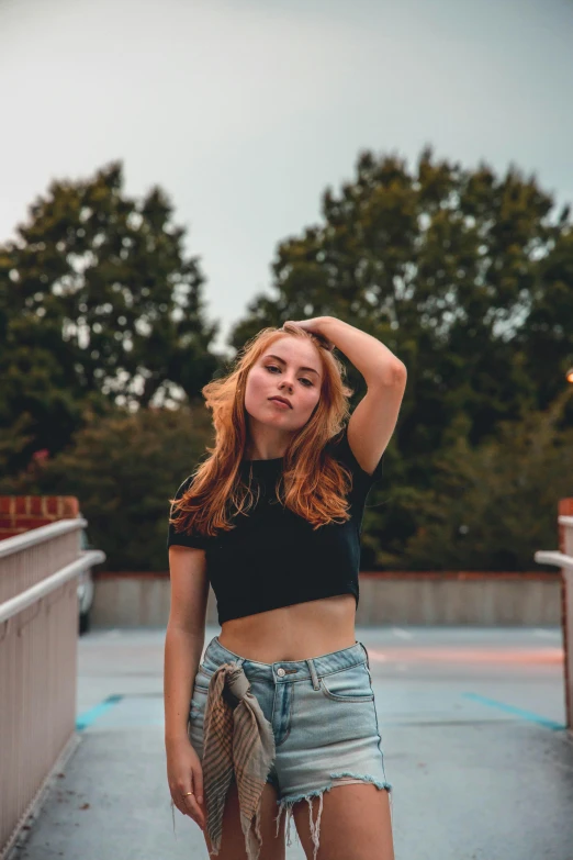 an attractive woman posing with her hands on her head