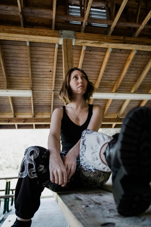 a beautiful young lady sitting on top of a wooden bench