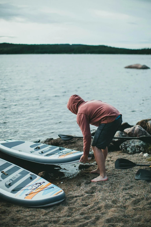 a person bending over with two surf boards