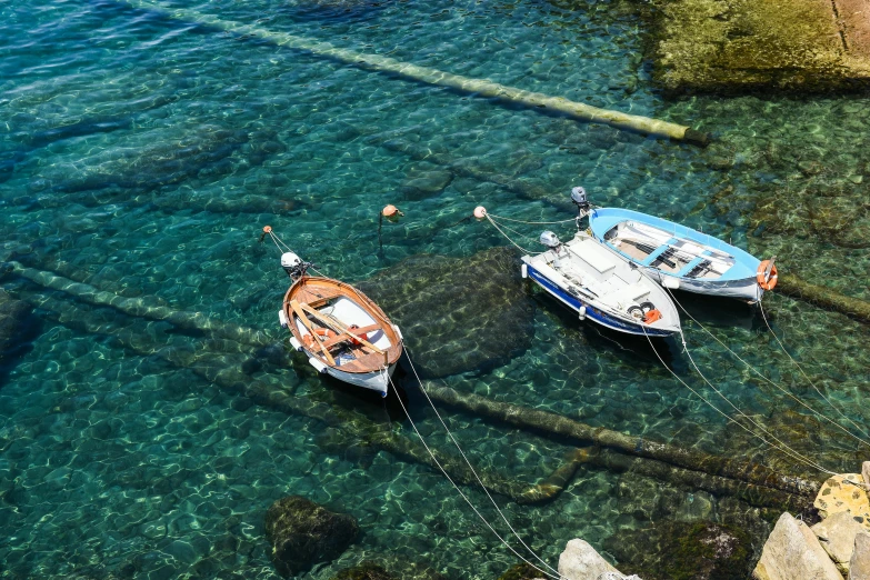 several boats tied up together in clear blue water