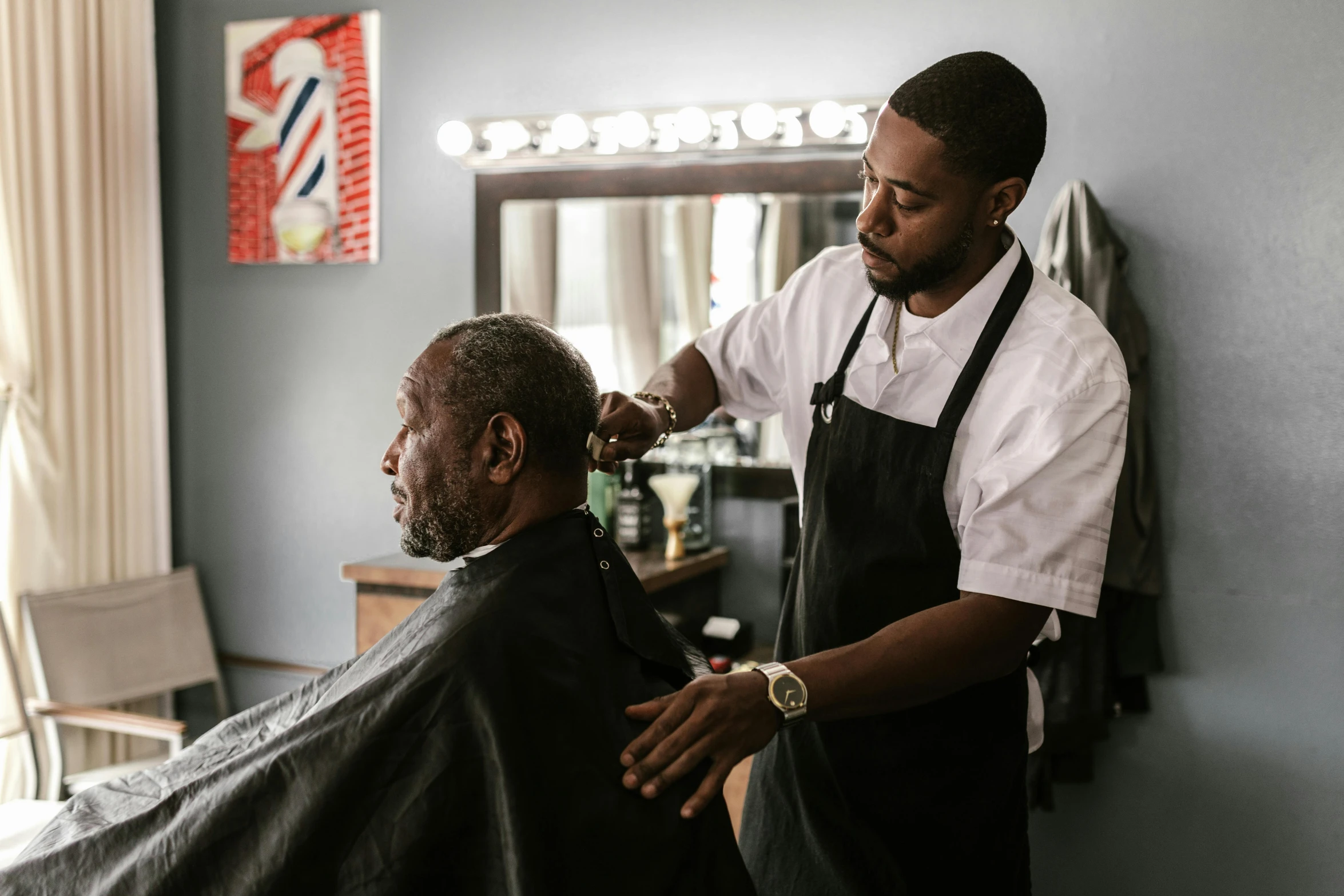 a man in a barbershop  another mans hair