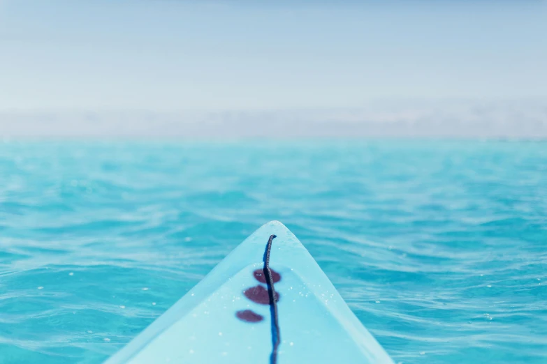 a person paddleboarding in a blue kayak on a bright day