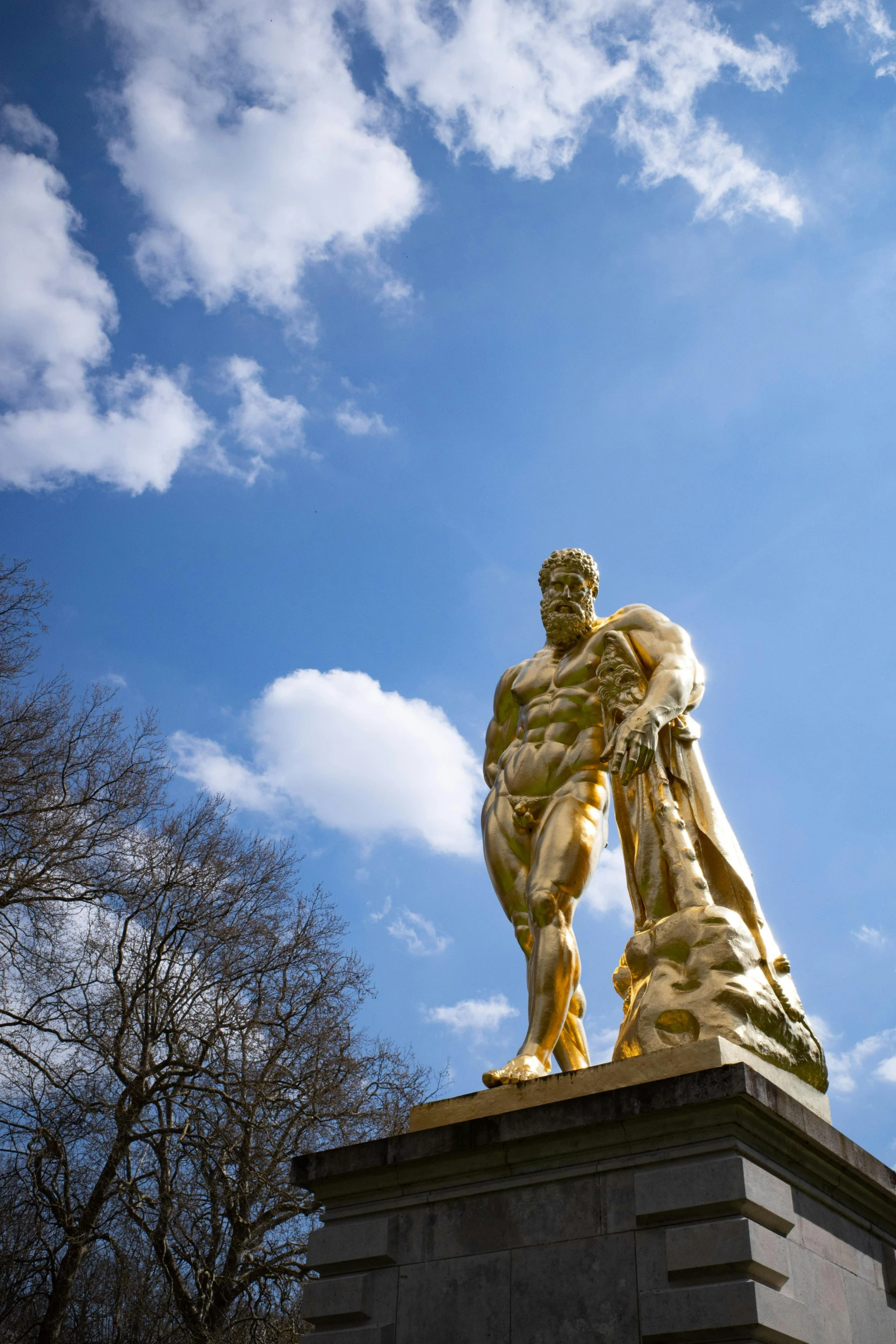 statue of two men standing next to each other under a cloudy blue sky