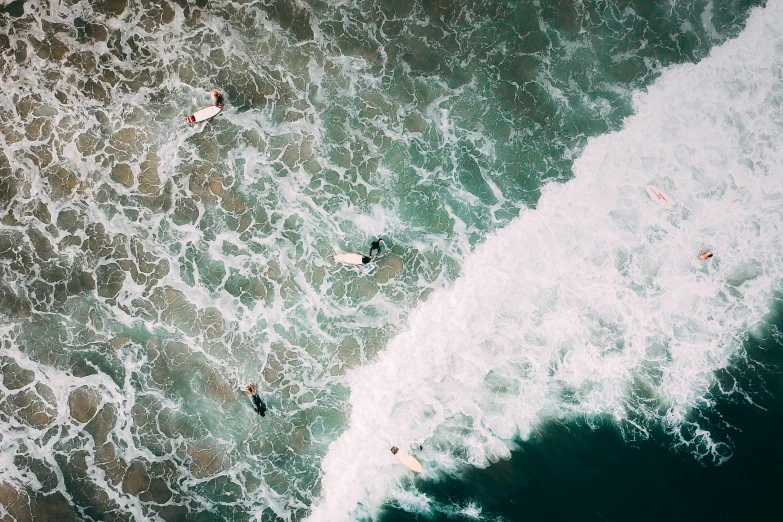 a po taken from above of two people on surfboards in the water