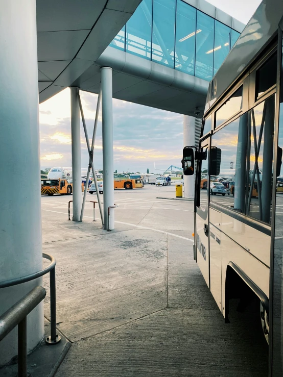 bus parked at airport parking lot with building in the background