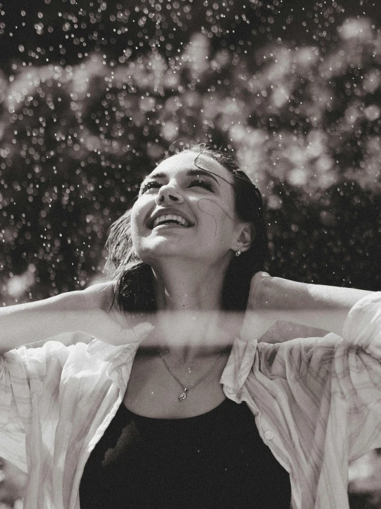 a woman smiles while standing in front of a tree