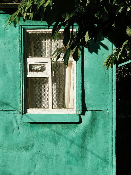 a close up of a green building with a window