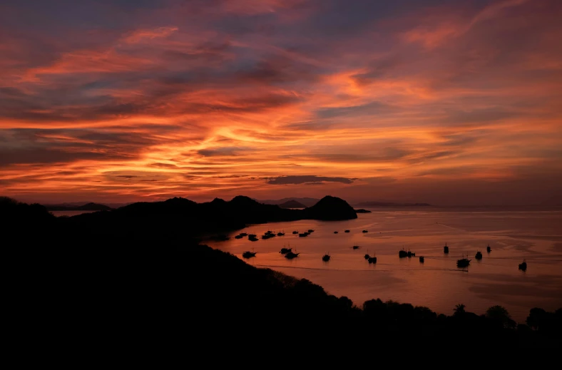 a sunset view shows boats sailing out to sea