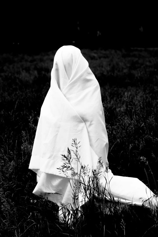 a white robe laying on top of grass in a field