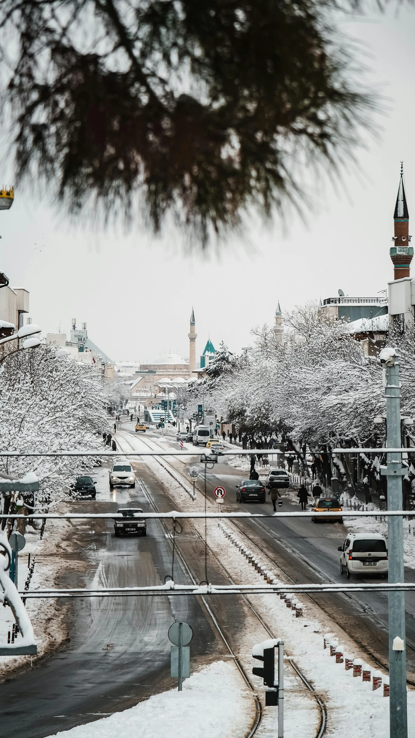 cars drive down a street covered with snow