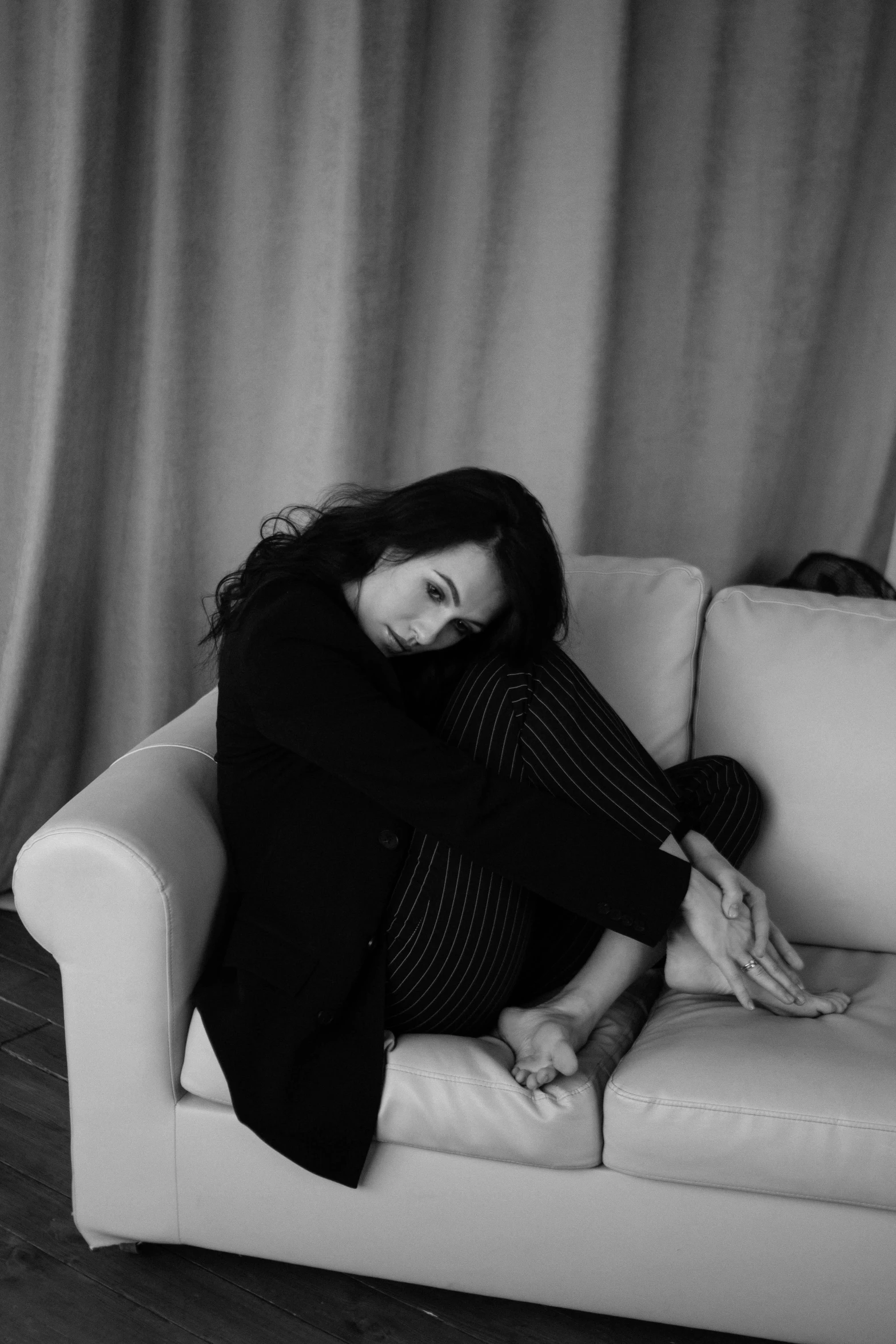 a black and white pograph of a person sitting on a couch