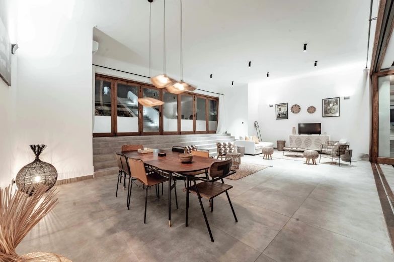 this large open dining area is white and features an elegant chandelier that adds warmth to the room