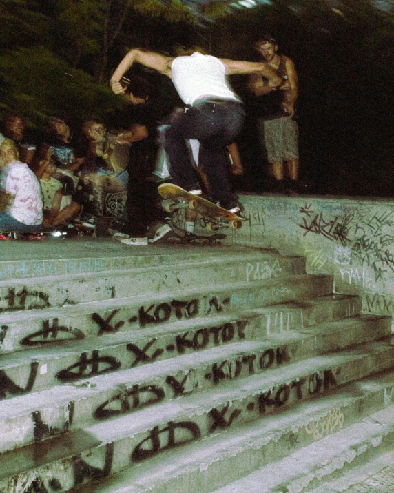 two boys perform skateboarding tricks on concrete steps in a city