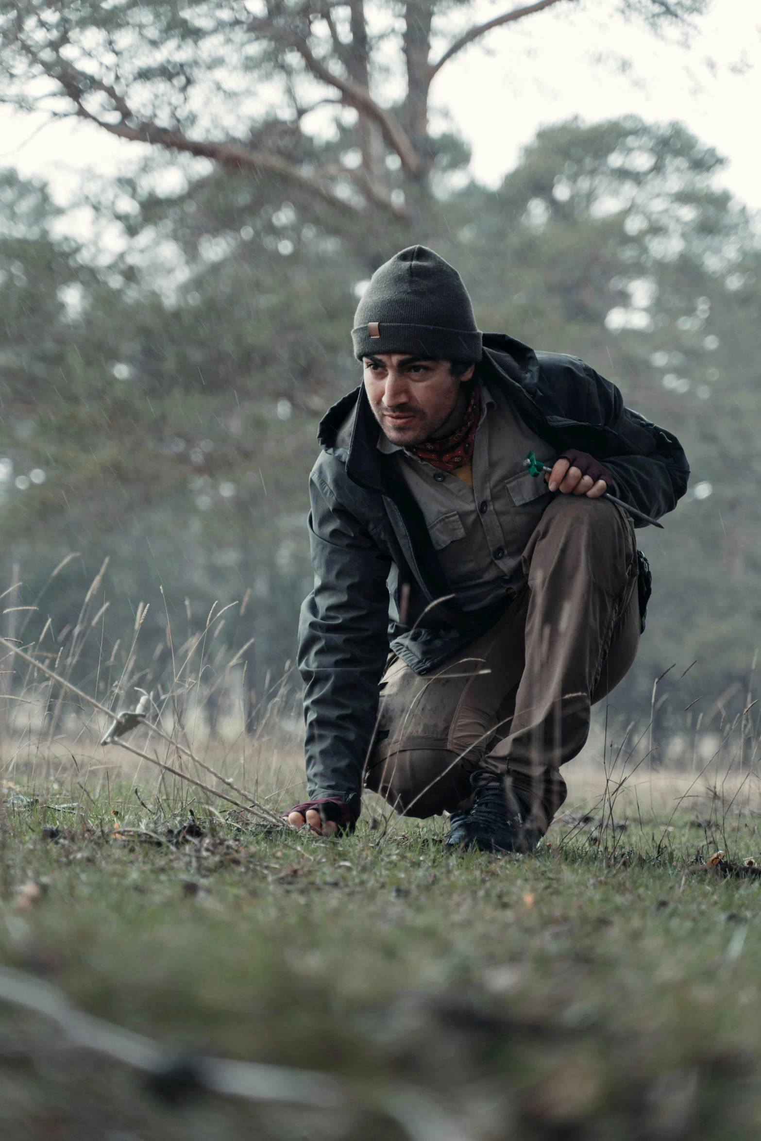 a man with a backpack is kneeling in the grass