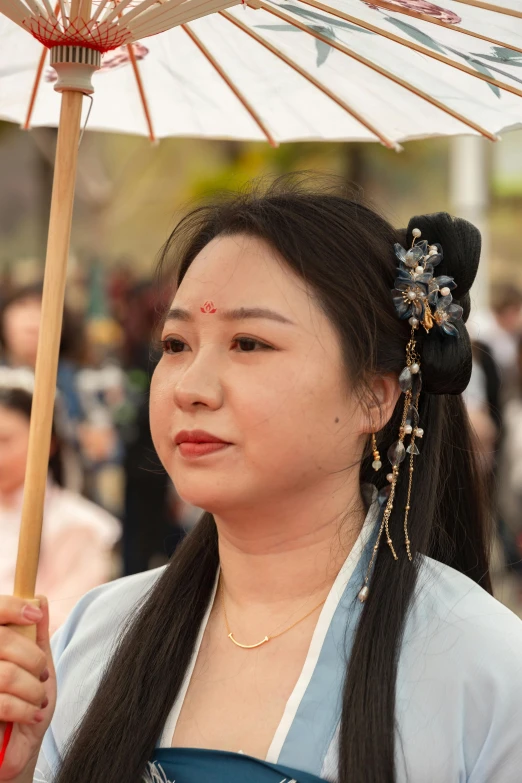 an oriental woman with long dark hair carrying an umbrella