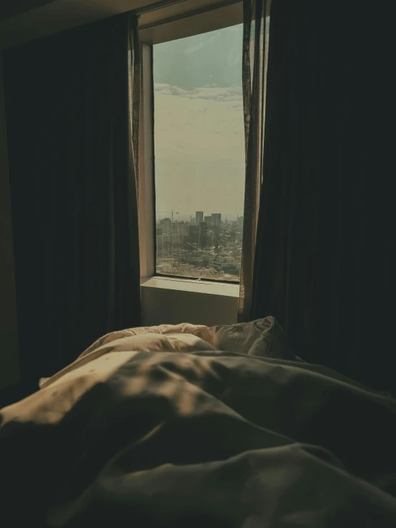 a bedroom scene looking out the window at buildings