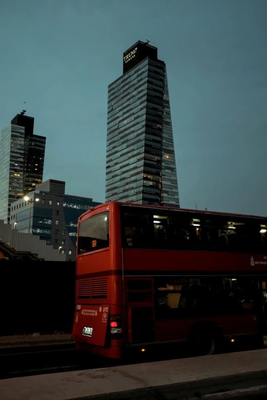 a red double decker bus driving through a city