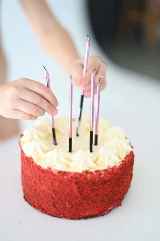 a woman is holding candles on top of a cake