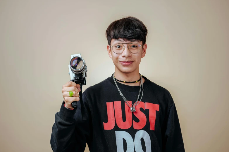 a man holding up a video camera with both hands