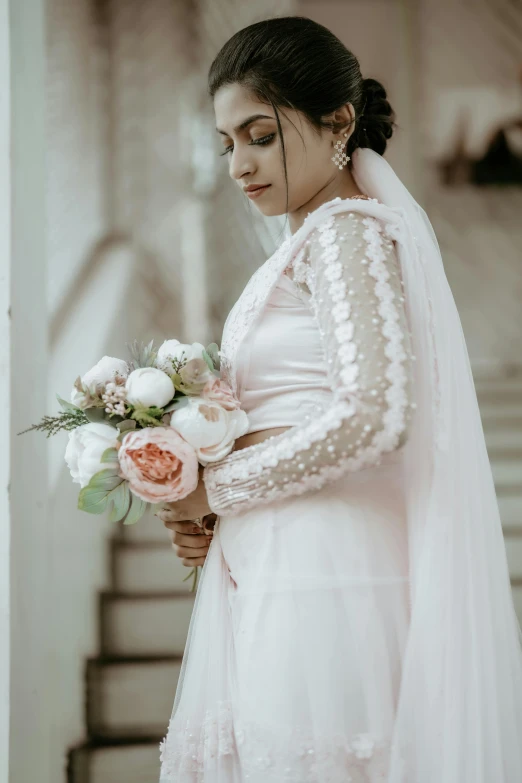 the bride looks over her shoulder, holding her bridal bouquet