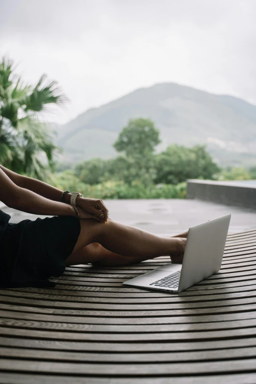 woman laying down on the floor while using her laptop