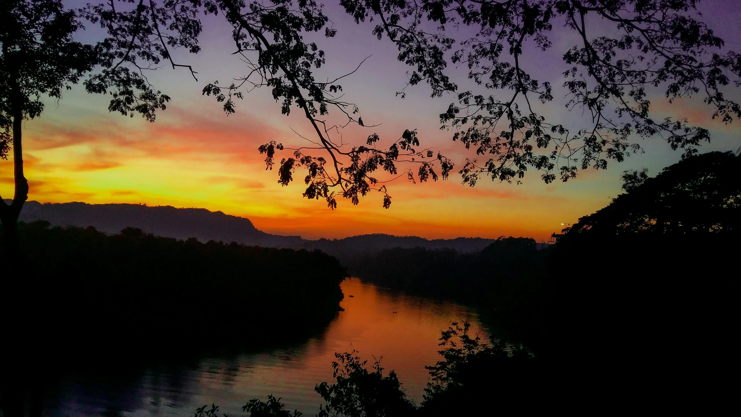 a view at a sunset over some trees