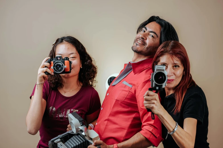 a man taking a po of two women holding cameras