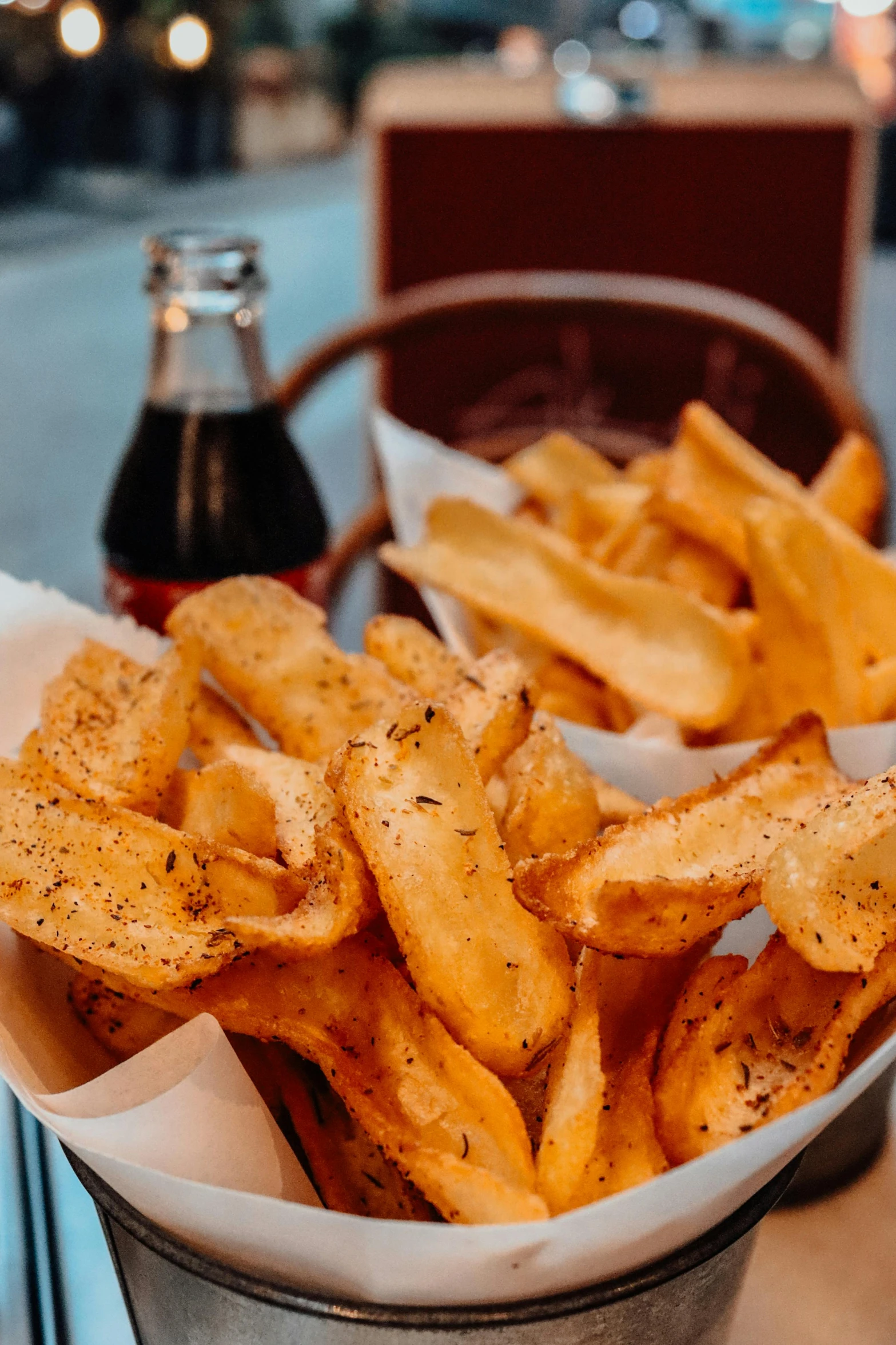 a container filled with fries sitting next to a bottle of coke