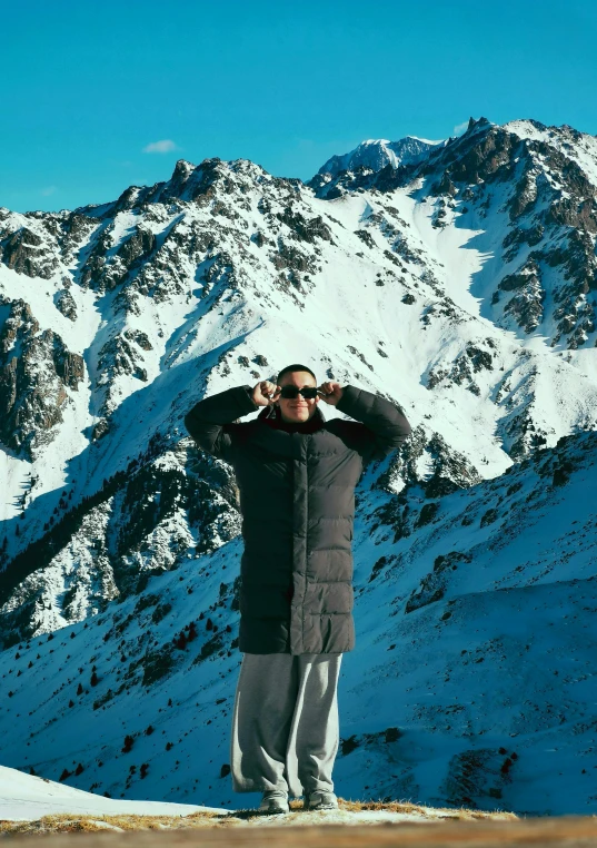 a man taking a picture in front of a mountain